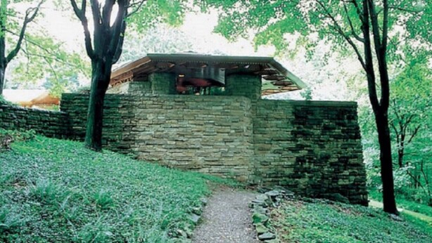 A stone structure with a sloped roof, surrounded by trees and a grassy area. - Pool Access | Fireplace, Deck & A/C (Somerset)