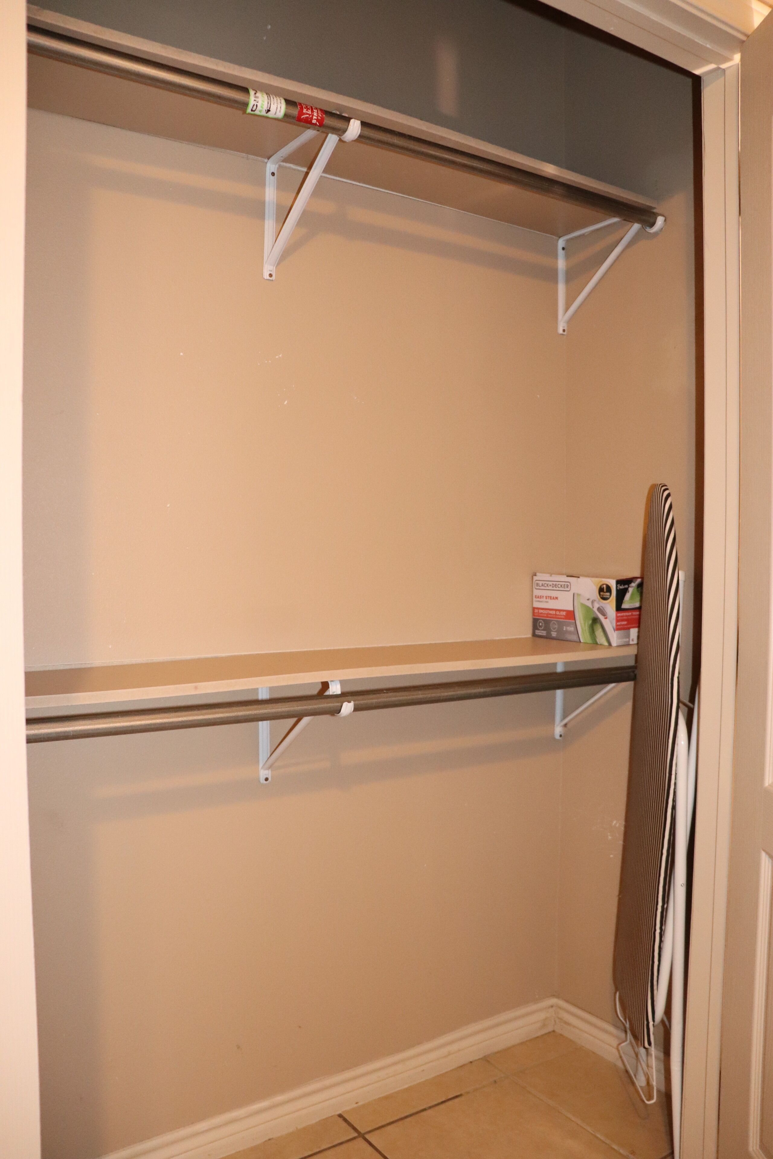 Een kleine, afgesloten kast met metalen planken en een verwarming.