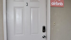 Une porte blanche portant le numéro 3, une pancarte indiquant « Réservé » et un trou de serrure.