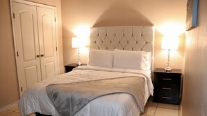 Une chambre à coucher avec un lit, deux tables de chevet et une armoire.