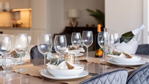 Une table à manger dressée avec des verres à vin, des assiettes et une bouteille de champagne.