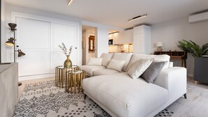 Un salon moderne avec un canapé, un tapis à motifs et une petite table d’appoint décorative.