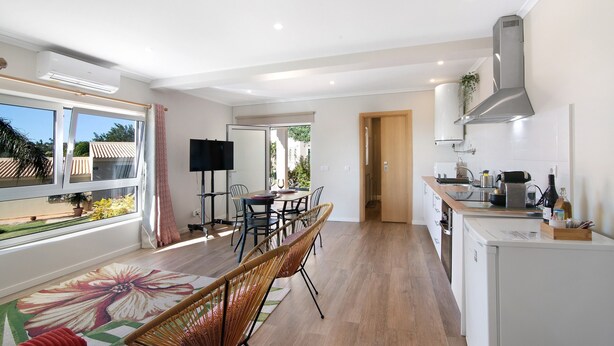 A modern kitchen with a dining area, large windows, and a view of the outdoors. - Holiday Home "Casa no Campo" with Sea View, Shared Pool and Wi-Fi (Loulé)