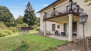 Un bâtiment à deux étages doté d’un balcon, d’un espace extérieur aménagé pour s’asseoir et d’un jardin.