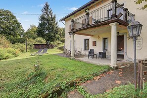 Un bâtiment à deux étages doté d’un balcon, d’un espace extérieur aménagé pour s’asseoir et d’un jardin.
