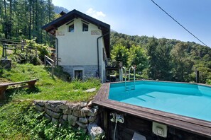 Una casa con piscina, scalini in pietra e terrazza in legno.