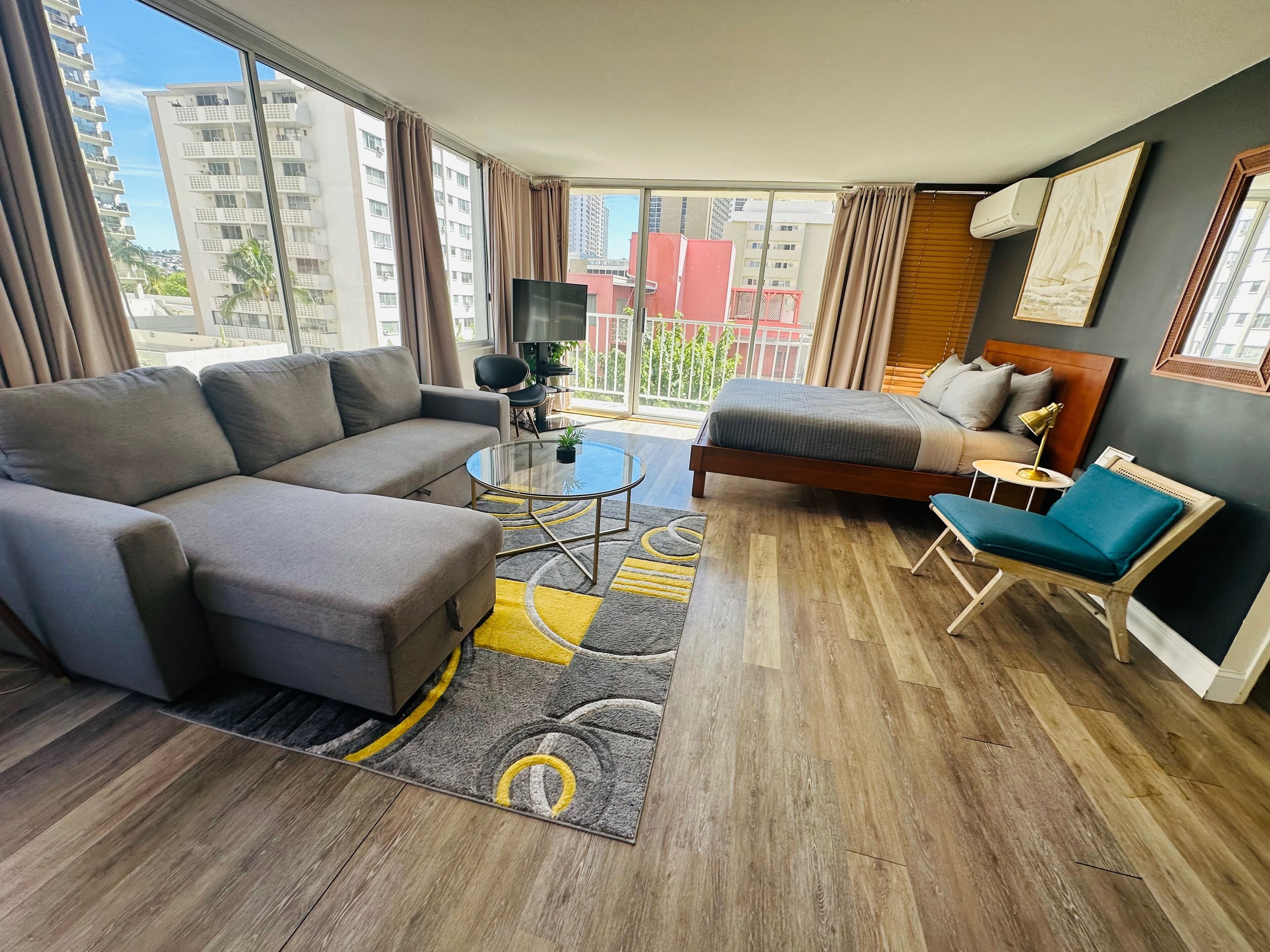 A modern hotel room with a sofa, bed, and a small table.