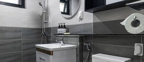 A modern bathroom with a toilet, sink, and shower.