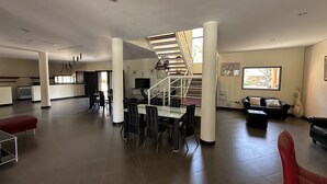 A spacious living area with a dining table, chairs, a staircase, and a sofa. - Sunset Village (Luperon)