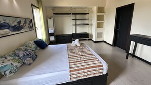 A bedroom with a bed, a dresser, a desk, a wardrobe, and a mirror. - Sunset Village (Luperon)