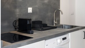 A modern kitchen with a built-in dishwasher, a coffee machine, and a stainless steel sink. - VLC HOST - Fray Pedro A (Valencia)