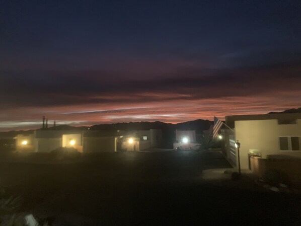 A residential area at dusk with houses and a clear sky.