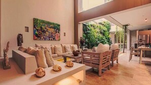Amplia sala de estar con un conjunto de sofás, una mesa de centro y un cuadro en la pared.