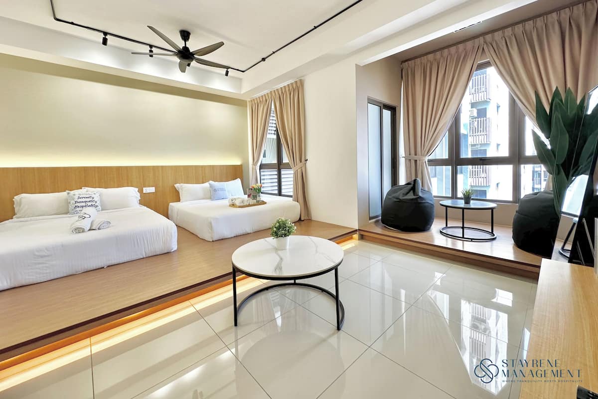 Een moderne hotelkamer met een groot bed, een bank, een bijzettafeltje en een uitzicht op de stad door grote ramen.