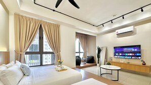 Une chambre d’hôtel avec deux lits, une télévision, un bureau et un balcon avec des rideaux.
