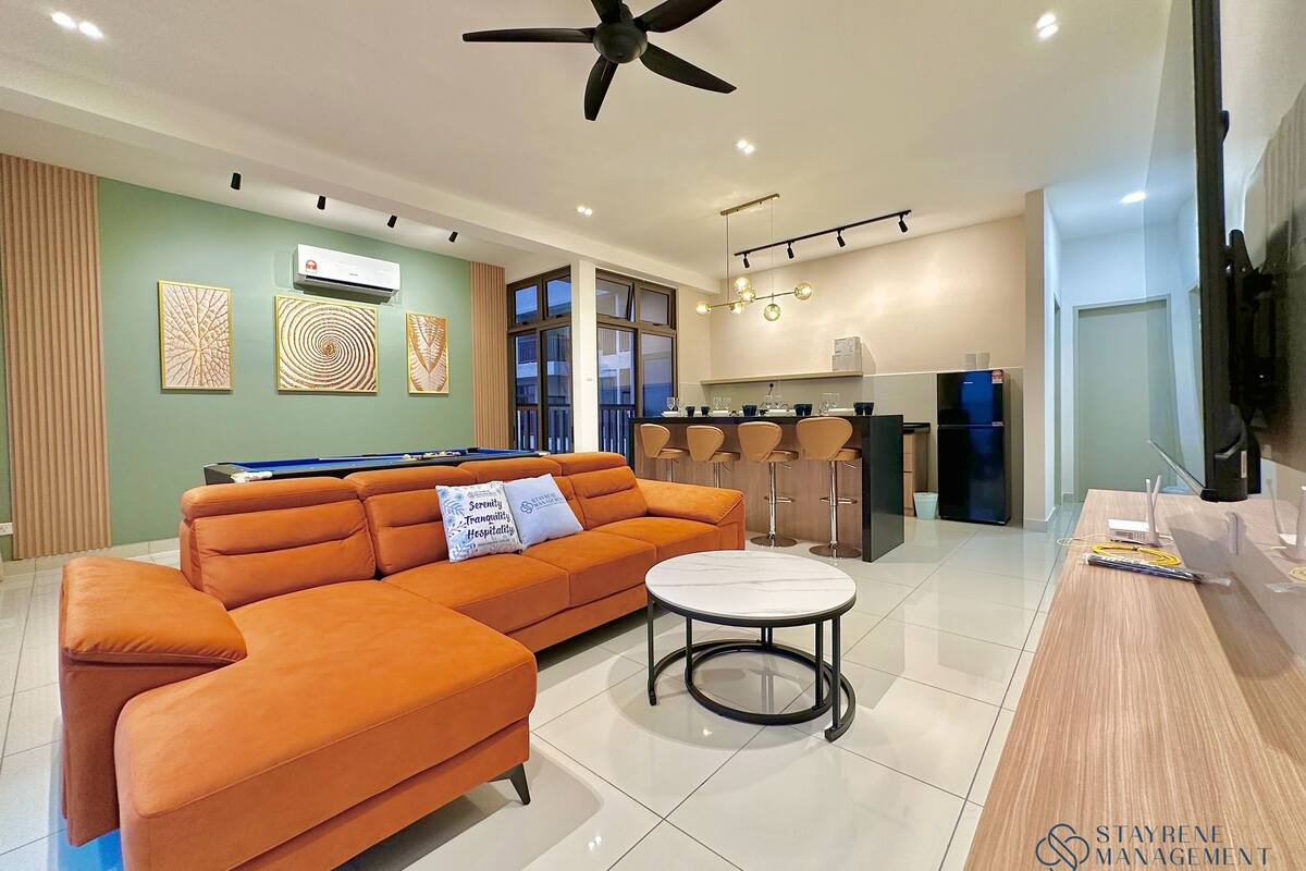 Een moderne woonkamer met een bank, een pooltafel en een keukenhoek.