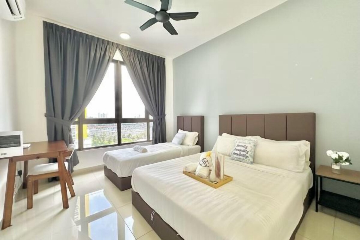 Habitación de hotel con cama, dos mesitas de noche, un escritorio y una ventana con cortinas.