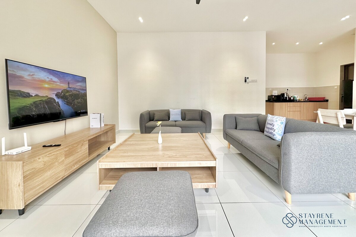Een moderne woonkamer met een flatscreen televisie, grijze banken, een houten salontafel en een plafondventilator.