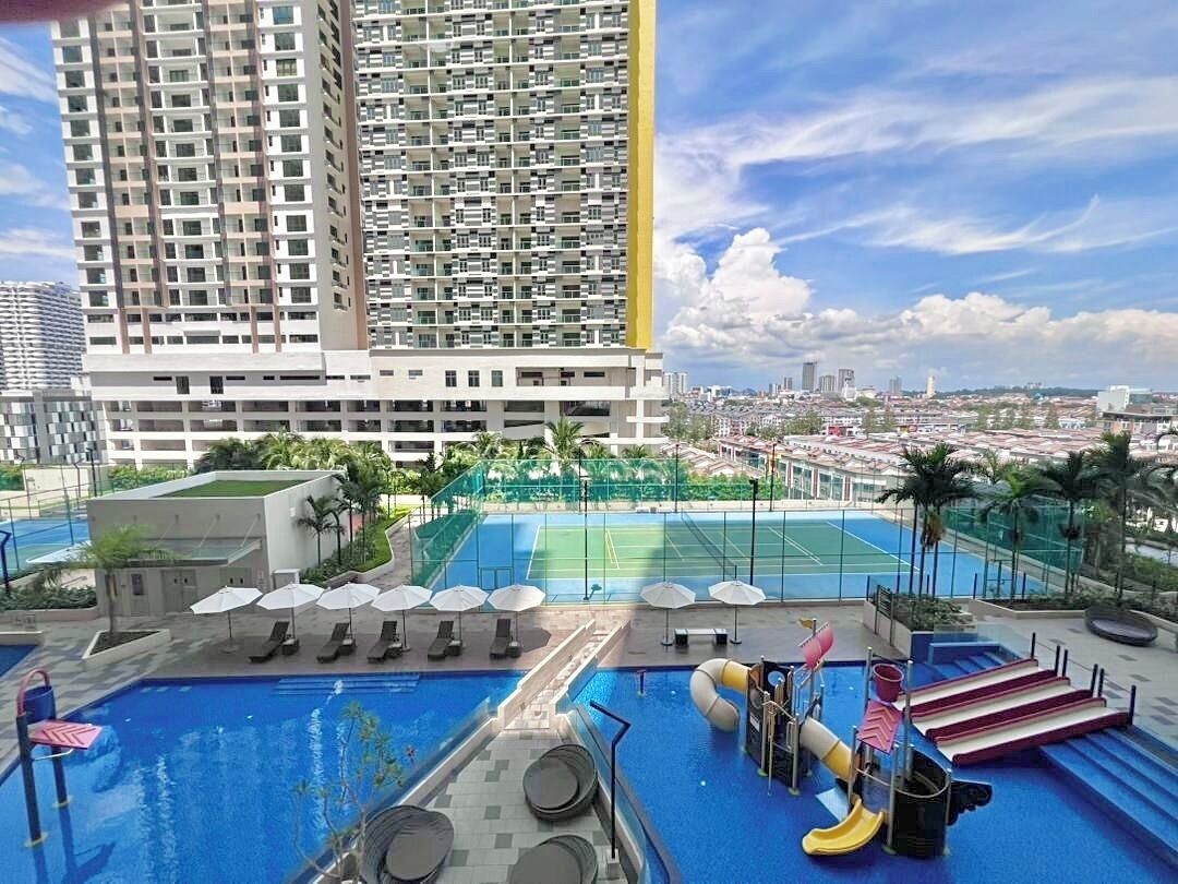 Ein Hochhaus mit Pool auf dem Dach, Wasserrutschen und einem Tennisplatz.