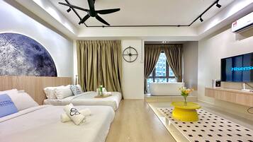 A hotel room with two beds, a ceiling fan, a large wall mural, a TV, and a view of a building through the window.