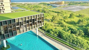 Un bâtiment moderne doté d’une piscine sur le toit et offrant une vue sur l’océan.