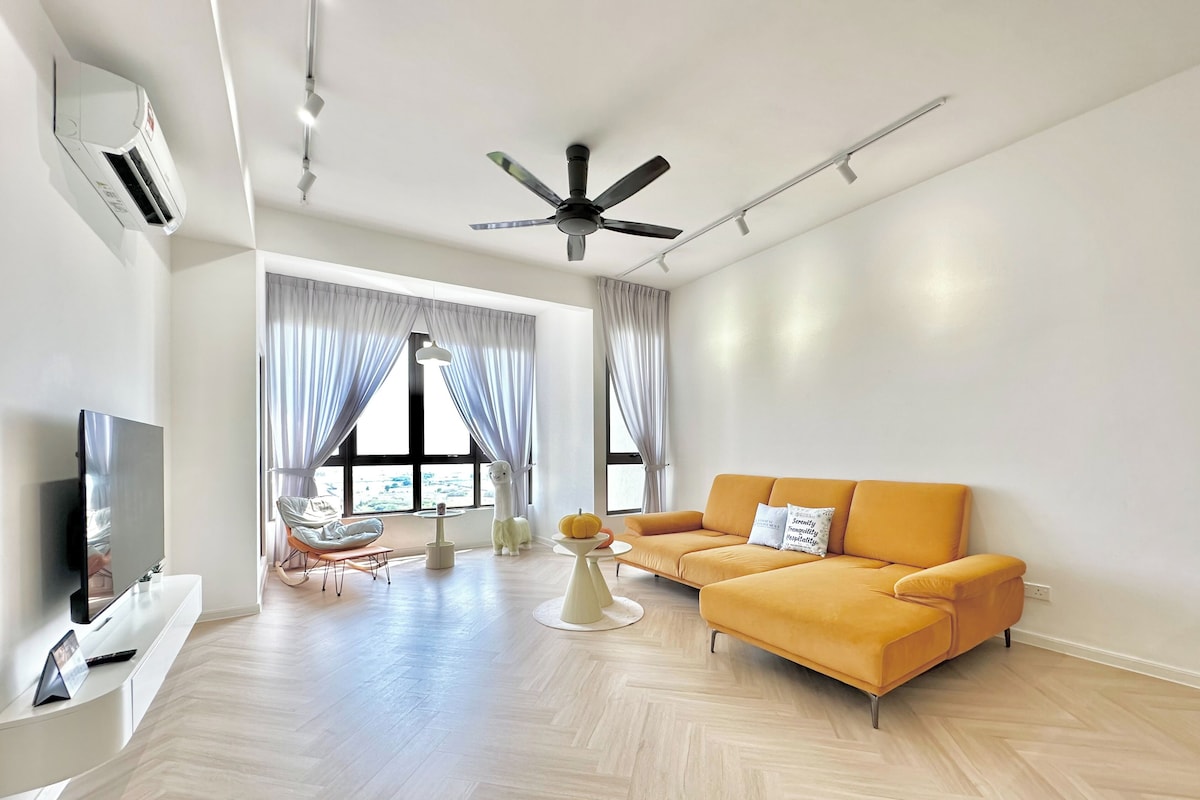 Una sala de estar moderna con un sofá, televisor y ventilador de techo.