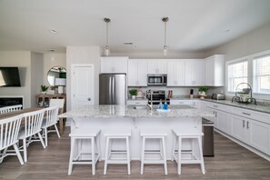 A modern kitchen with white cabinets, stainless steel appliances, and a granite countertop. - The Common House - 7 min to LU, Family Friendly, Great Location, sleeps up to 8! (Lynchburg)