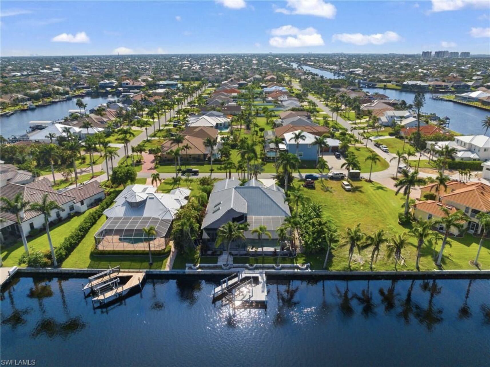 An aerial view of a residential area with houses, a marina, and a river.