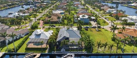 An aerial view of a residential area with houses, a marina, and a river.