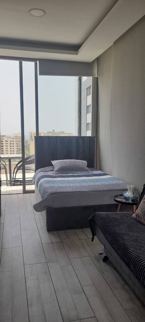 Un dormitorio moderno con una cama grande, una mesita y un sofá.