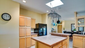 A kitchen with wooden cabinets, a black refrigerator, a built-in oven, and a hanging pot rack. - 11 Mi to Saguaro Nat'l Park! Family Home w/ Deck (Tucson)