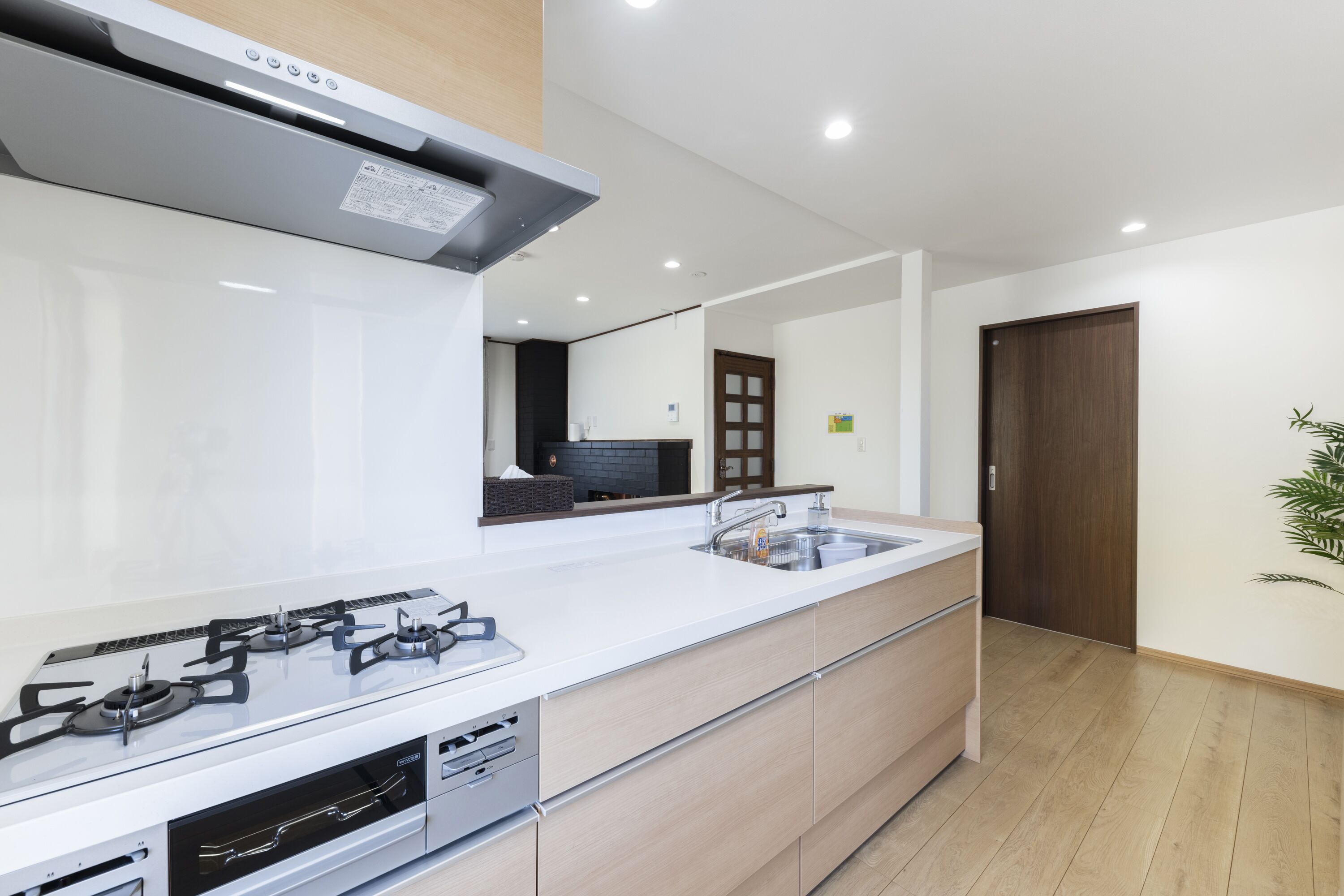 A modern kitchen with a white countertop, stainless steel appliances, and wooden cabinets.