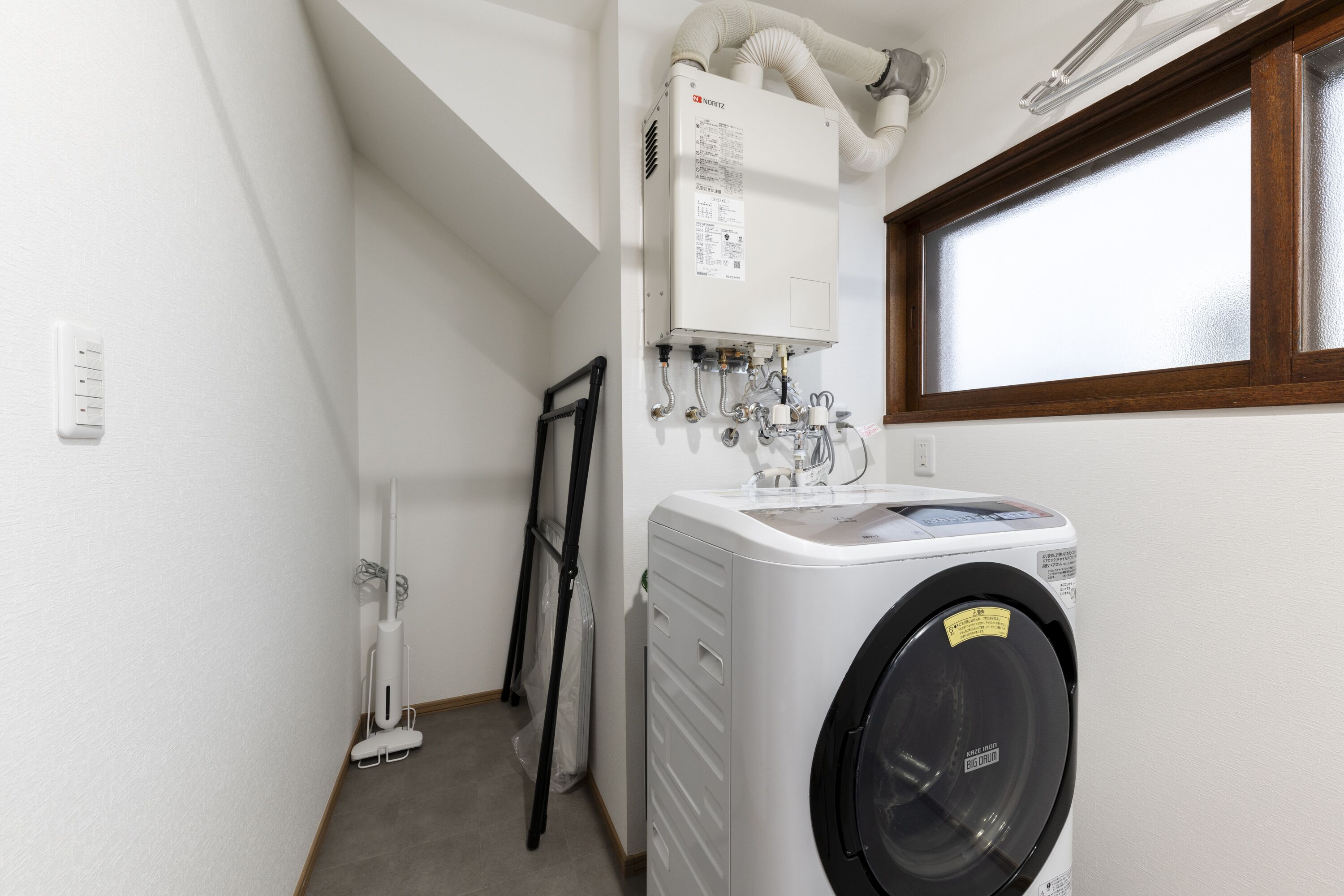 A laundry area with a washing machine, a dryer, and a water heater.