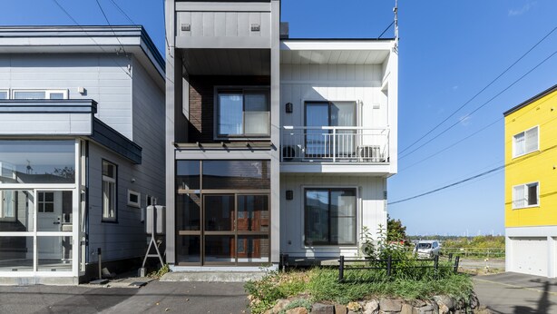 A modern multi-story building with large windows and a balcony. - COSMIC HILL (Sapporo)