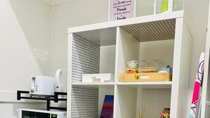 Une cuisine compacte équipée d’un four à micro-ondes, d’une bouilloire et d’un réfrigérateur.