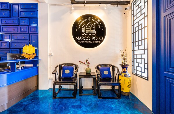 Un área de recepción con el logo de Marco Polo, con temática náutica y una paleta de colores azules.