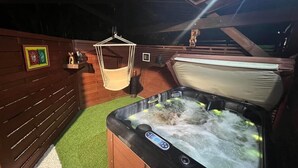 A hot tub in a wooden cabin with a hanging chair and a hammock. - Havre de Paix - Bungalow de Charme (Baie-Mahault)
