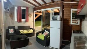 A compact kitchen with a sink, stove, and a small refrigerator. - Havre de Paix - Bungalow de Charme (Baie-Mahault)