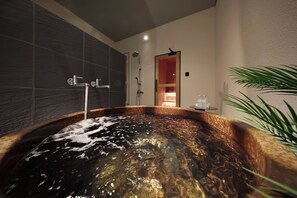 A modern bathroom with a large bathtub, a shower area, and a visible door leading to another room. - Crystal Villa SHIRARAHAMA BEACH (Shirahama)