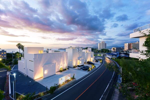 Uma rua urbana moderna com edifícios contemporâneos, uma estrada sinuosa e céu claro.