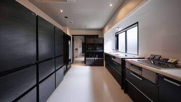 Una cocina moderna con una isla central, muebles negros y un amplio ventanal que proporciona luz natural.