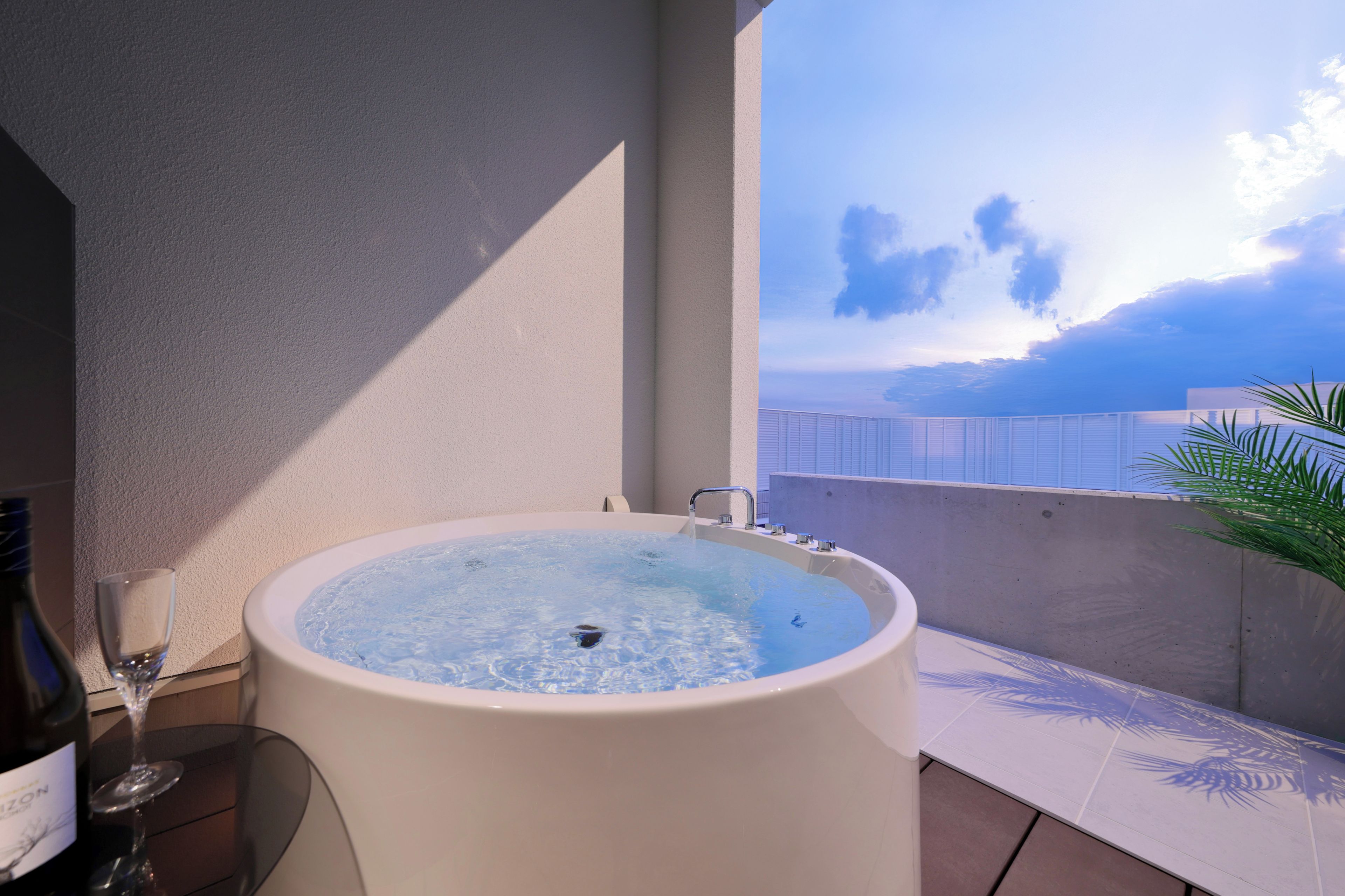 A hot tub on a balcony with a clear sky view.