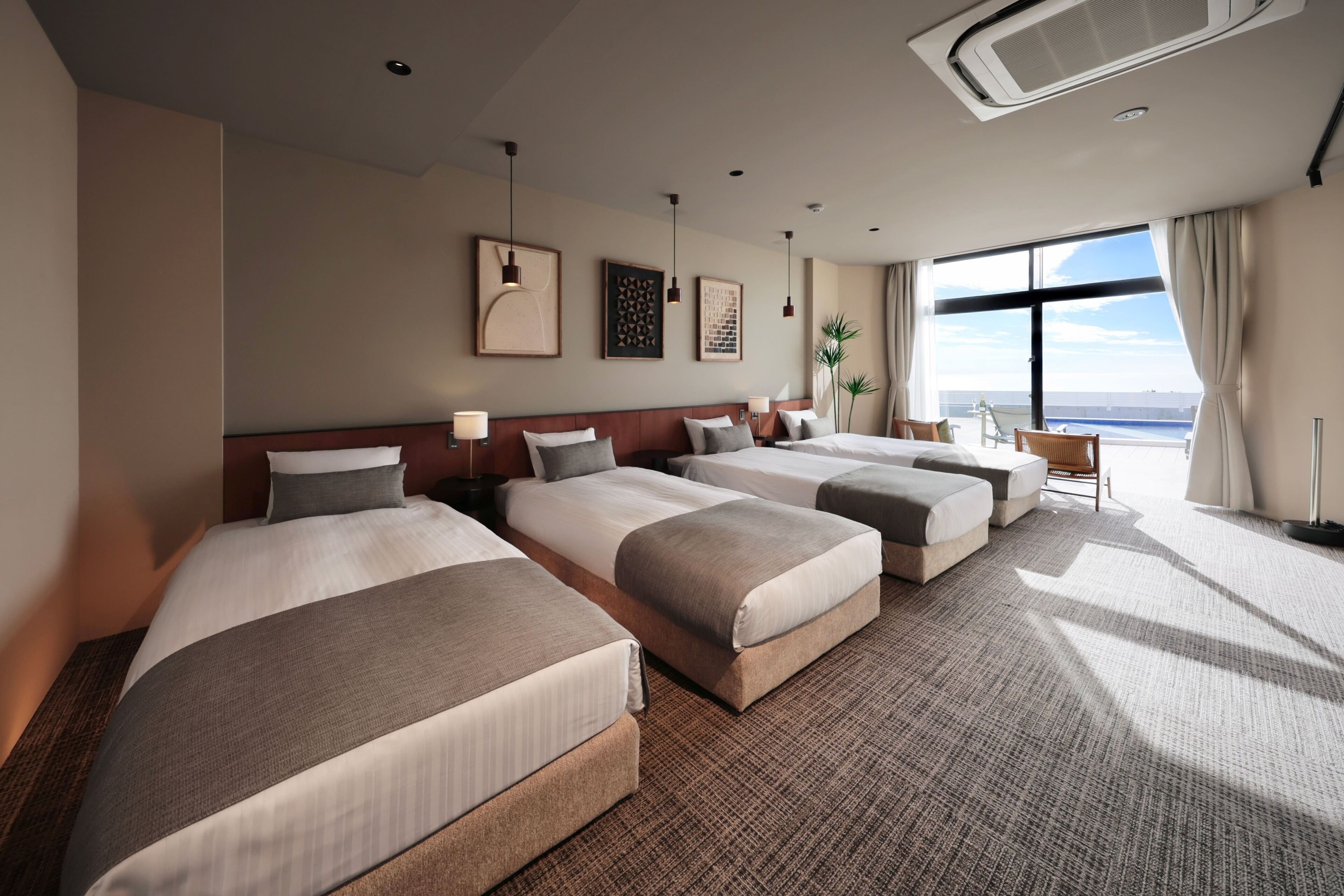 Quarto de hotel com quatro camas, uma janela grande e vista panorâmica, e design moderno.