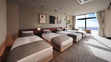 Quarto de hotel com quatro camas, uma janela grande e vista panorâmica, e design moderno.