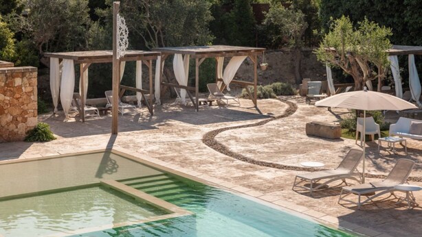 A pool area with a clear water section, lounge chairs, and a pergola with draped fabric. - Cava Li Santi Residence - Monolocale Family Int 2 (Santa Caterina)