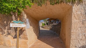 A stone tunnel entrance with a sign reading "piscina". - Cava Li Santi Residence - Monolocale Family Int 2 (Santa Caterina)