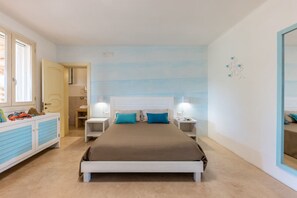 Une chambre à coucher comprenant un lit, des tables de chevet, une commode et un grand miroir.