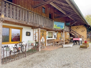 Ein Holzhaus mit Balkon, Fahrrädern und einem Schild mit der Aufschrift 'Persil'.