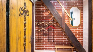 A wooden door with a metal cross, a brick wall, a wooden staircase, and a mirror. - Holiday Apartment 'Fachwerkferienhaus' with Lake View, Terrace & Wi-Fi (Ulrichshusen)