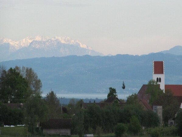 A mountain range with a church and residential buildings in the foreground.